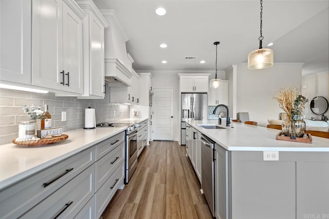 kitchen featuring decorative backsplash, appliances with stainless steel finishes, a sink, ornamental molding, and recessed lighting
