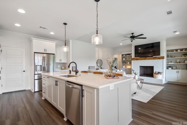 kitchen featuring ceiling fan, visible vents, appliances with stainless steel finishes, a sink, and ornamental molding