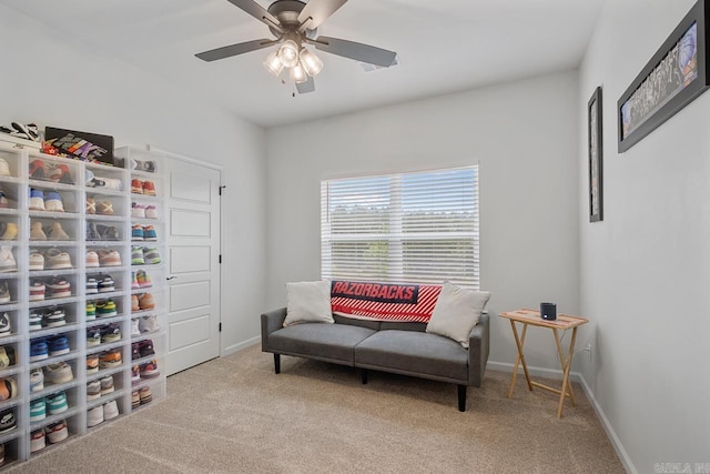 sitting room featuring ceiling fan, baseboards, and carpet