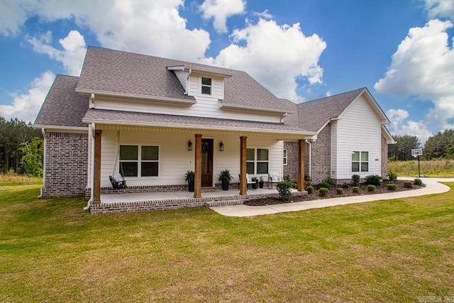 view of front facade featuring roof with shingles, a front lawn, and brick siding