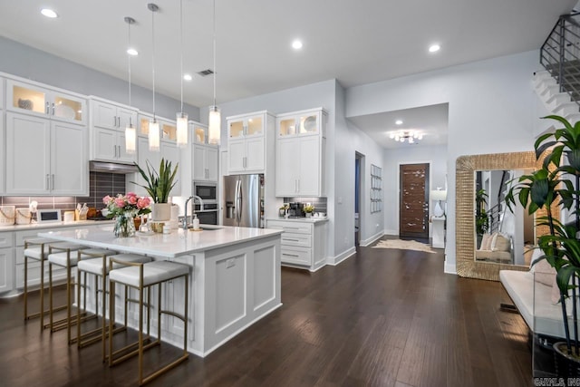 702 Wildcreek Cir, Little Rock, AR 72223 - kitchen with light countertops, decorative backsplash, built in microwave, and stainless steel fridge with ice dispenser