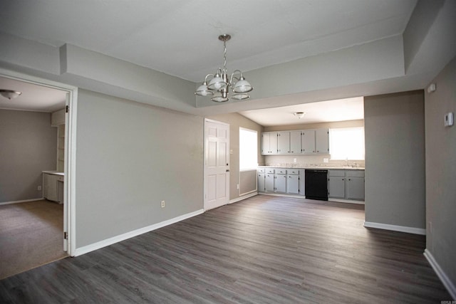 unfurnished dining area featuring a healthy amount of sunlight, baseboards, dark wood-type flooring, and a chandelier