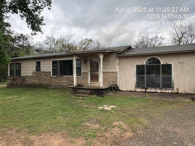 single story home with stone siding and a front yard