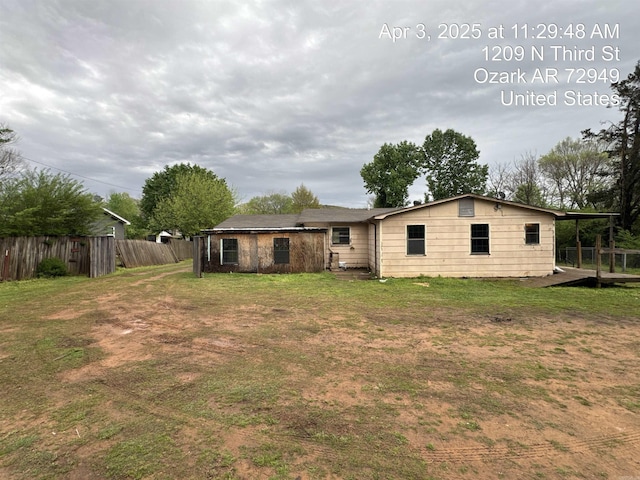 back of house with a lawn and fence