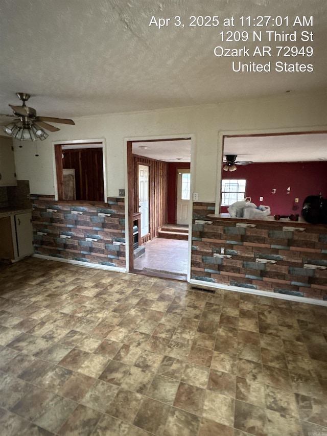 unfurnished living room featuring ceiling fan