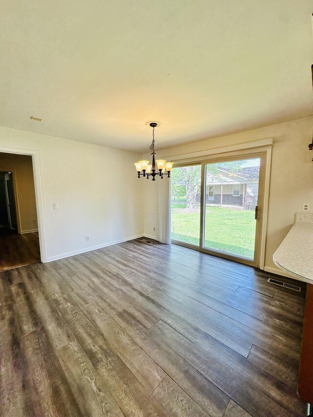 320 Church, Weiner, AR 72479 - unfurnished dining area with baseboards, visible vents, dark wood-type flooring, and a chandelier