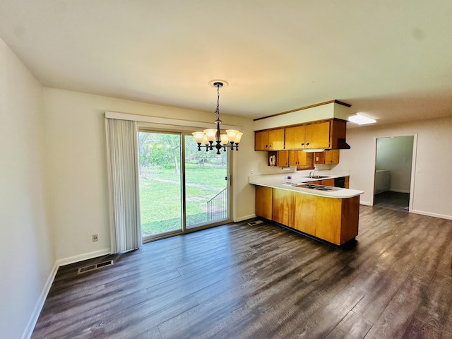 320 Church, Weiner, AR 72479 - kitchen featuring a notable chandelier, light countertops, dark wood finished floors, a peninsula, and baseboards