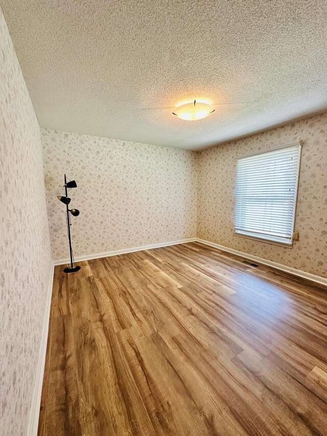 320 Church, Weiner, AR 72479 - unfurnished room with a textured ceiling and wood finished floors