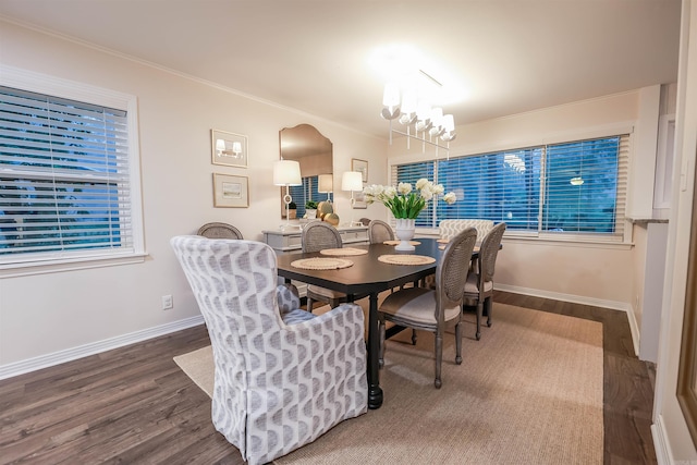 dining space with baseboards, crown molding, wood finished floors, and an inviting chandelier