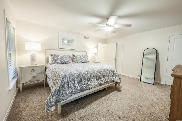 carpeted bedroom with visible vents, baseboards, and ceiling fan