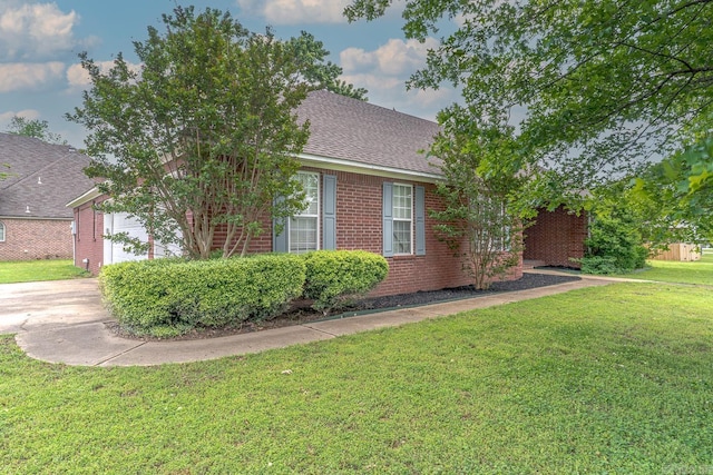 1010 Brownstone Dr, Jonesboro, AR 72404 - view of home's exterior featuring a lawn, a shingled roof, a garage, and brick siding