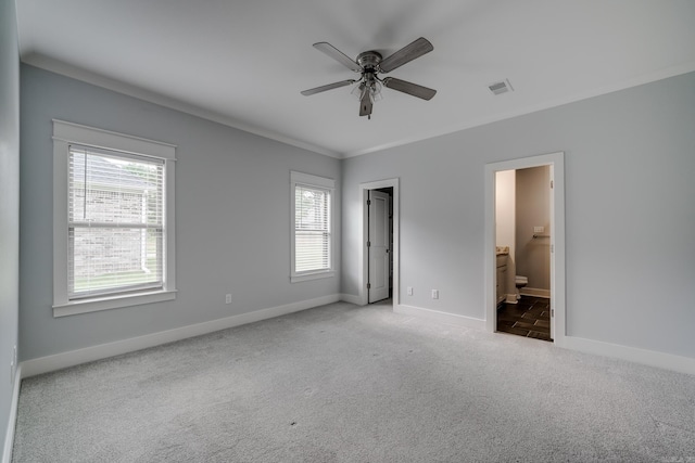 unfurnished bedroom with visible vents, baseboards, connected bathroom, ornamental molding, and carpet