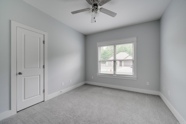 empty room featuring carpet floors, baseboards, and a ceiling fan