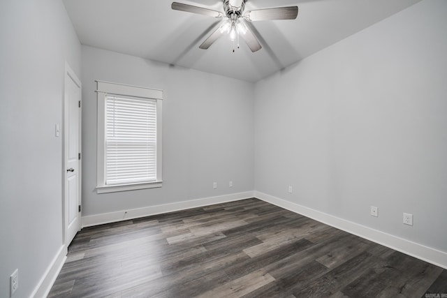 spare room with baseboards, a ceiling fan, and dark wood-style flooring