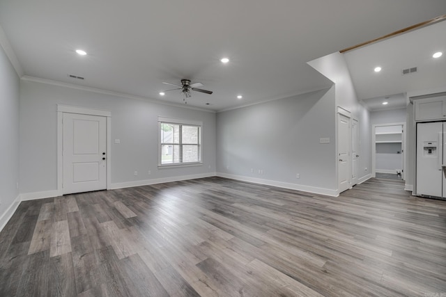 unfurnished living room featuring ceiling fan, visible vents, wood finished floors, baseboards, and ornamental molding