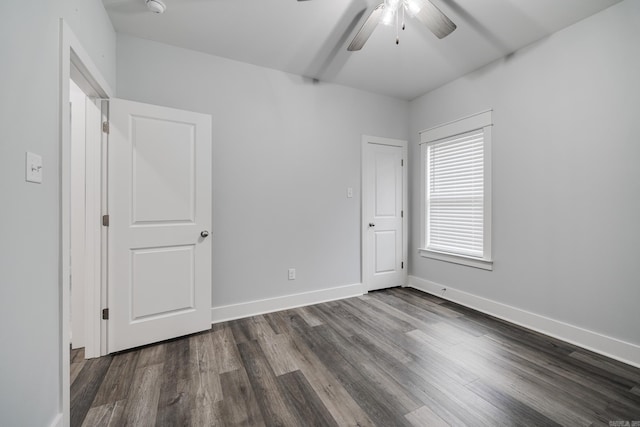 unfurnished bedroom featuring baseboards, ceiling fan, and dark wood-type flooring