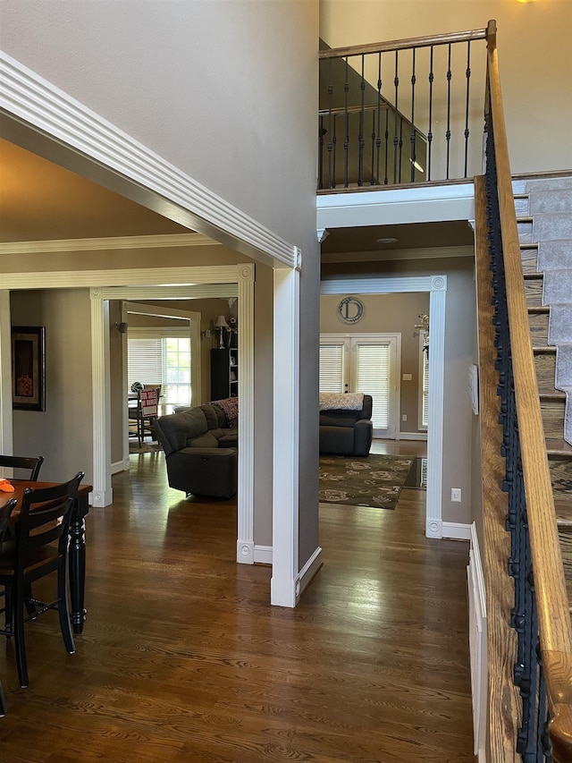 interior space with baseboards, ornamental molding, and wood finished floors