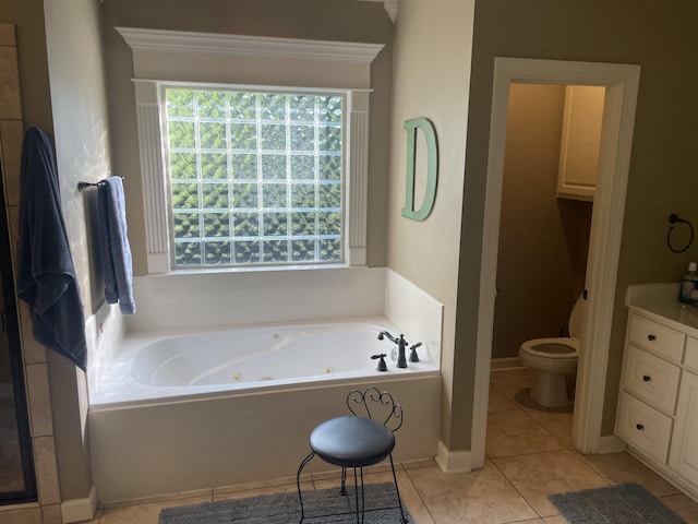 full bathroom with tile patterned floors, toilet, and a tub with jets