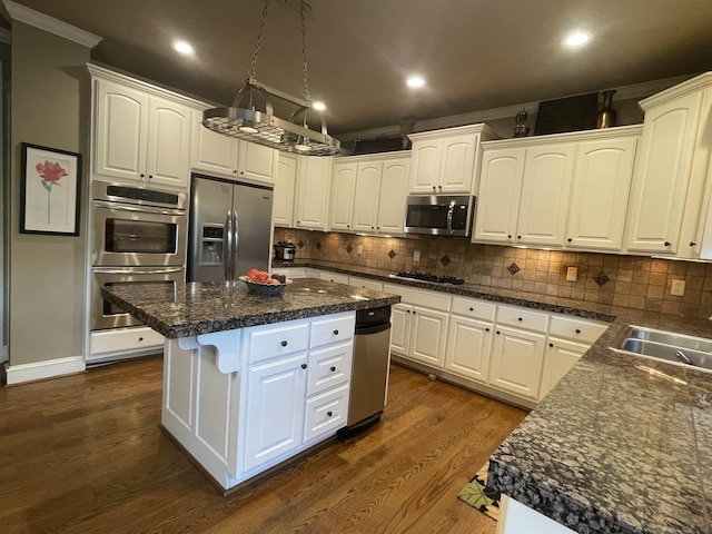 kitchen featuring a sink, dark countertops, stainless steel appliances, and white cabinetry