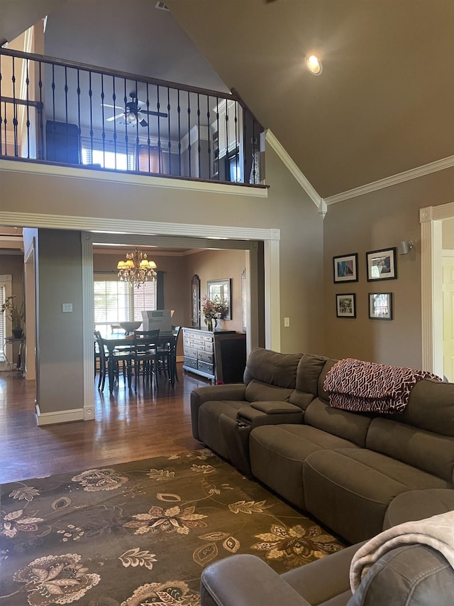 living room featuring wood finished floors, high vaulted ceiling, baseboards, a chandelier, and ornamental molding