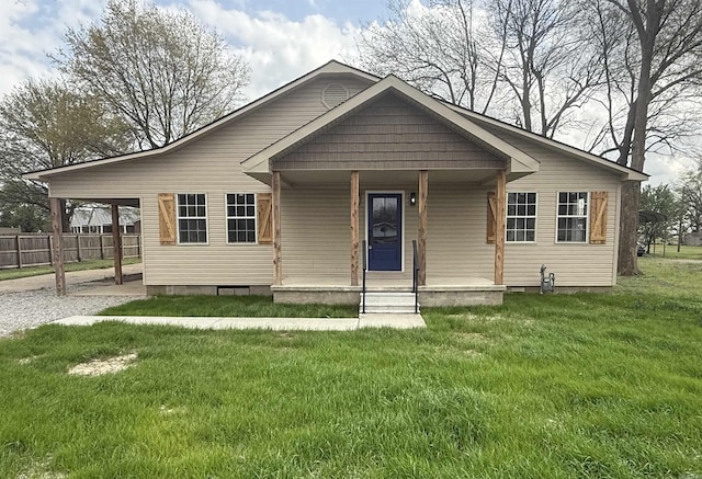bungalow featuring a porch, crawl space, fence, a front lawn, and an attached carport