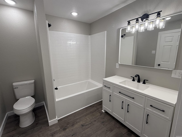 full bath featuring bathtub / shower combination, vanity, toilet, baseboards, and wood finished floors