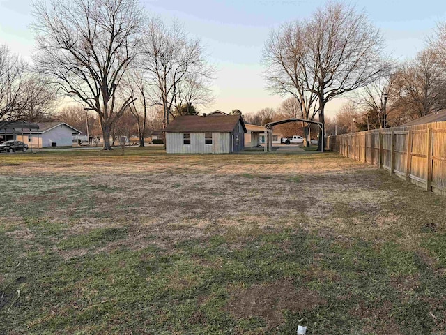 view of yard with fence and a detached carport