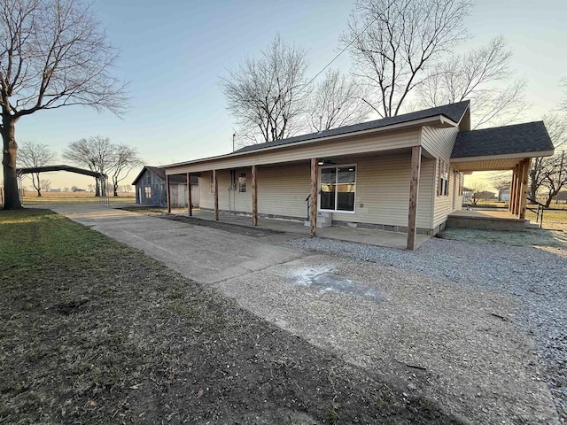 view of front facade with roof with shingles, a porch, and driveway