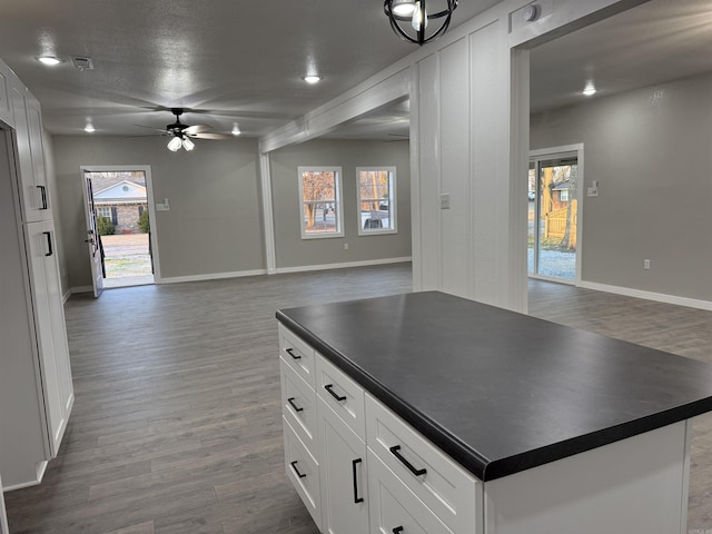 kitchen with a ceiling fan, dark countertops, and open floor plan