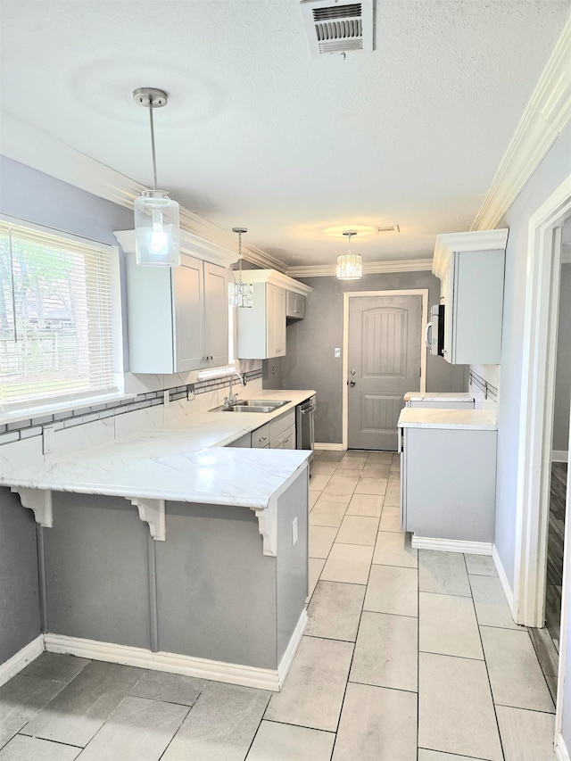 kitchen with a kitchen breakfast bar, visible vents, crown molding, a sink, and a peninsula