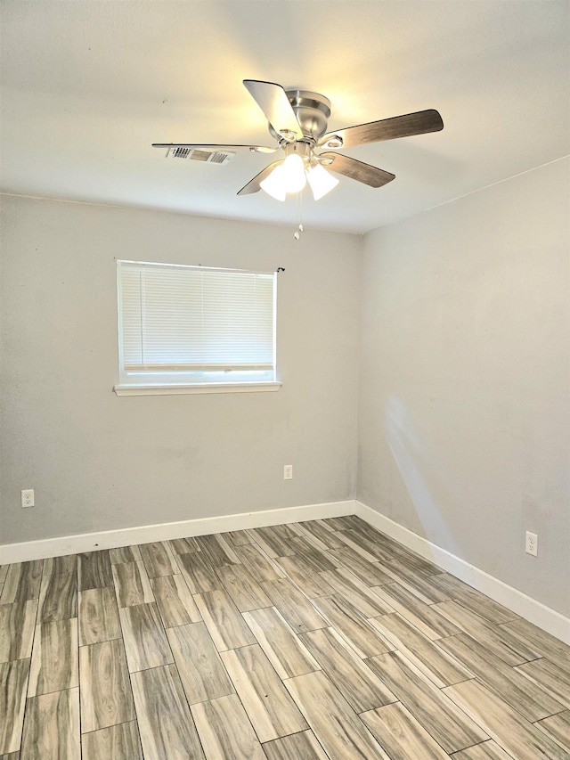 unfurnished room with visible vents, baseboards, ceiling fan, and wood finished floors