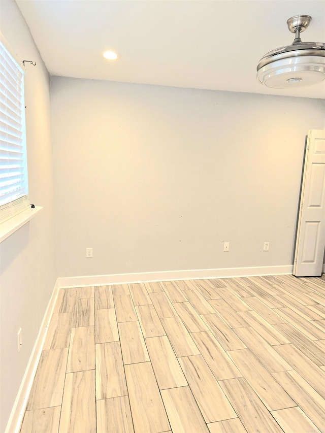 empty room featuring recessed lighting, baseboards, and light wood-type flooring