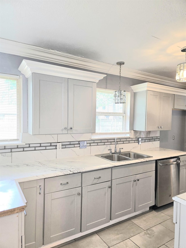 kitchen with crown molding, a sink, dishwasher, a chandelier, and backsplash