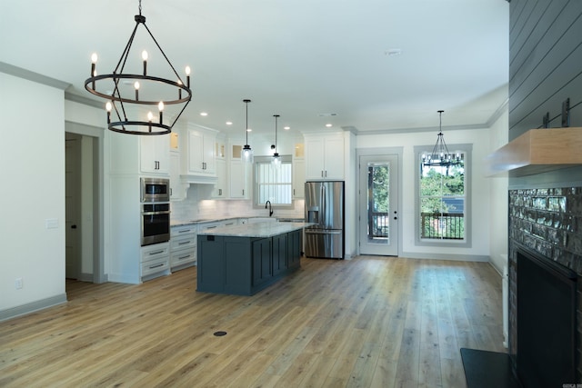100 Laurie Dr, Mena, AR 71953 - kitchen featuring appliances with stainless steel finishes, tasteful backsplash, a sink, white cabinets, and a chandelier