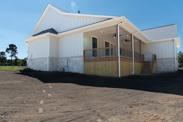 100 Laurie Dr, Mena, AR 71953 - exterior space featuring board and batten siding, a ceiling fan, brick siding, a shingled roof, and stairs