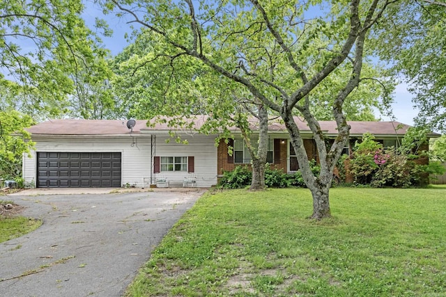 ranch-style home featuring an attached garage, a front lawn, and aphalt driveway