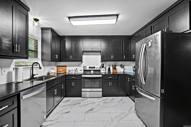kitchen featuring appliances with stainless steel finishes, dark countertops, a sink, marble finish floor, and extractor fan