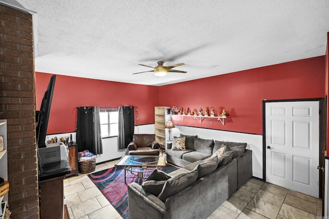 living room with a wood stove, a textured ceiling, and ceiling fan