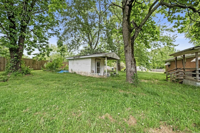 view of yard featuring an outdoor structure and fence