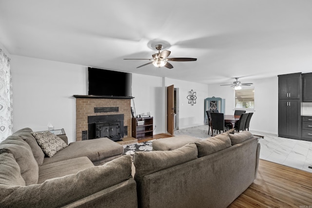 living area with ceiling fan, baseboards, marble finish floor, and a fireplace