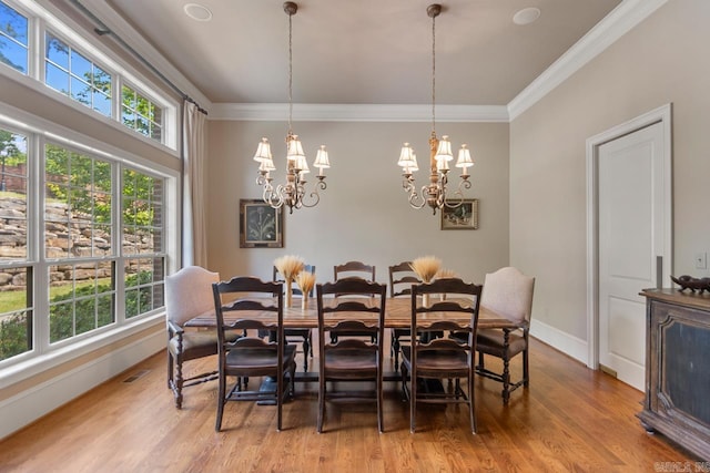 10 Lakewood Park Dr, North Little Rock, AR 72116 - dining space with a notable chandelier, ornamental molding, a wealth of natural light, and light wood-type flooring