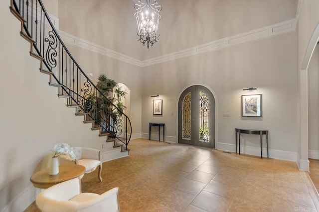 10 Lakewood Park Dr, North Little Rock, AR 72116 - tiled foyer with an inviting chandelier, stairs, a towering ceiling, baseboards, and arched walkways