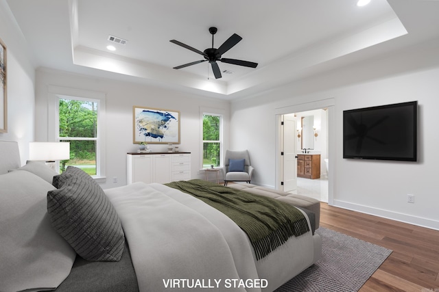 2940 Orchard View Dr, Conway, AR 72034 - bedroom with visible vents, wood finished floors, a tray ceiling, and multiple windows
