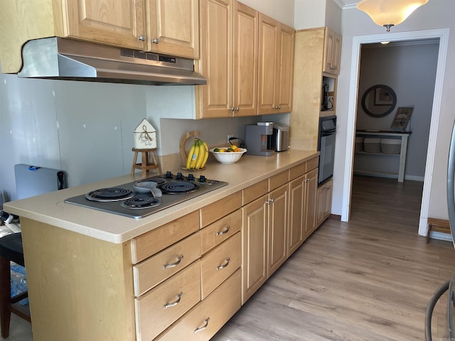 kitchen featuring under cabinet range hood, oven, stainless steel electric stovetop, light countertops, and light wood-type flooring