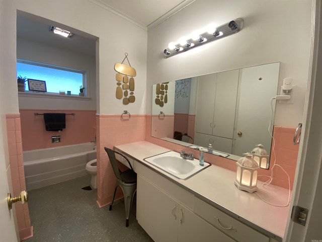 bathroom with a wainscoted wall, crown molding, toilet, vanity, and a tub