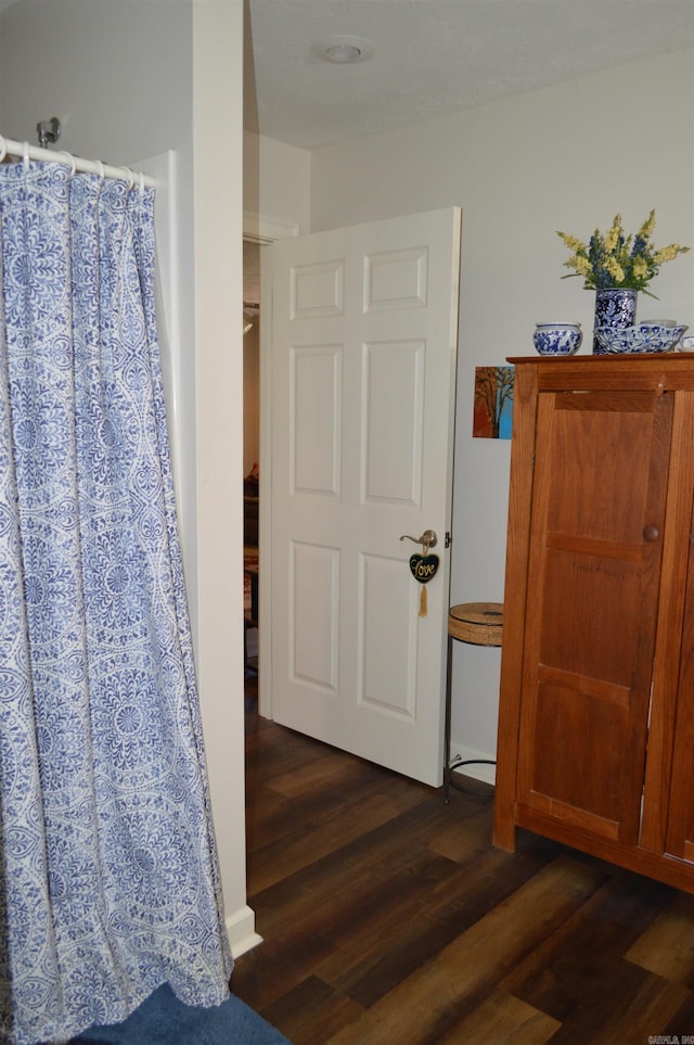 interior space with a shower with curtain and wood finished floors
