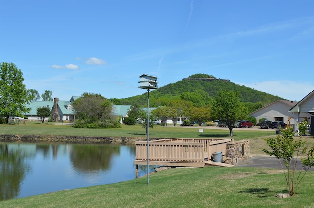 surrounding community with a lawn and a water and mountain view