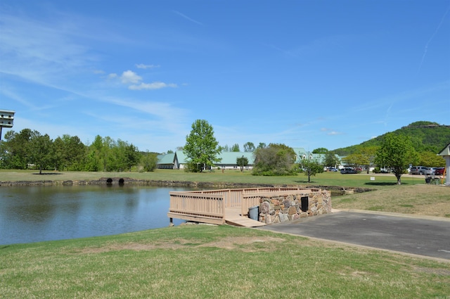 dock area with a lawn and a water view