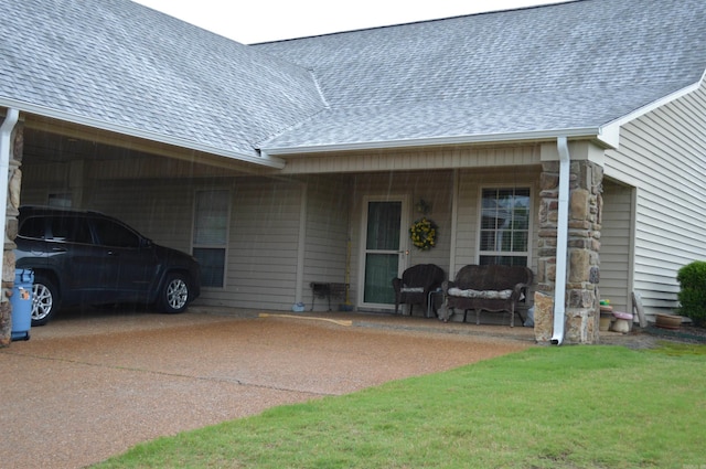 view of front facade featuring roof with shingles, a front yard, and an attached carport