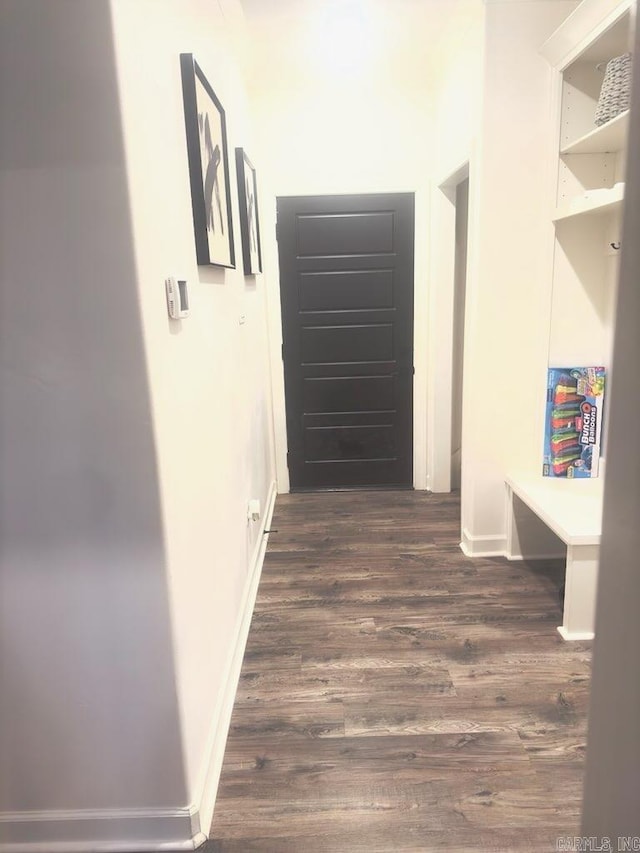 corridor with dark wood-type flooring and baseboards